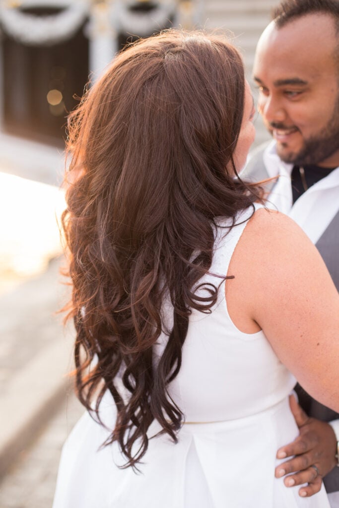 Close-up of a girl's curly hair tied with a red bow