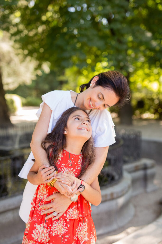 Mother hugging her smiling daughter from behind during a mother daughter photoshoot in Madrid
