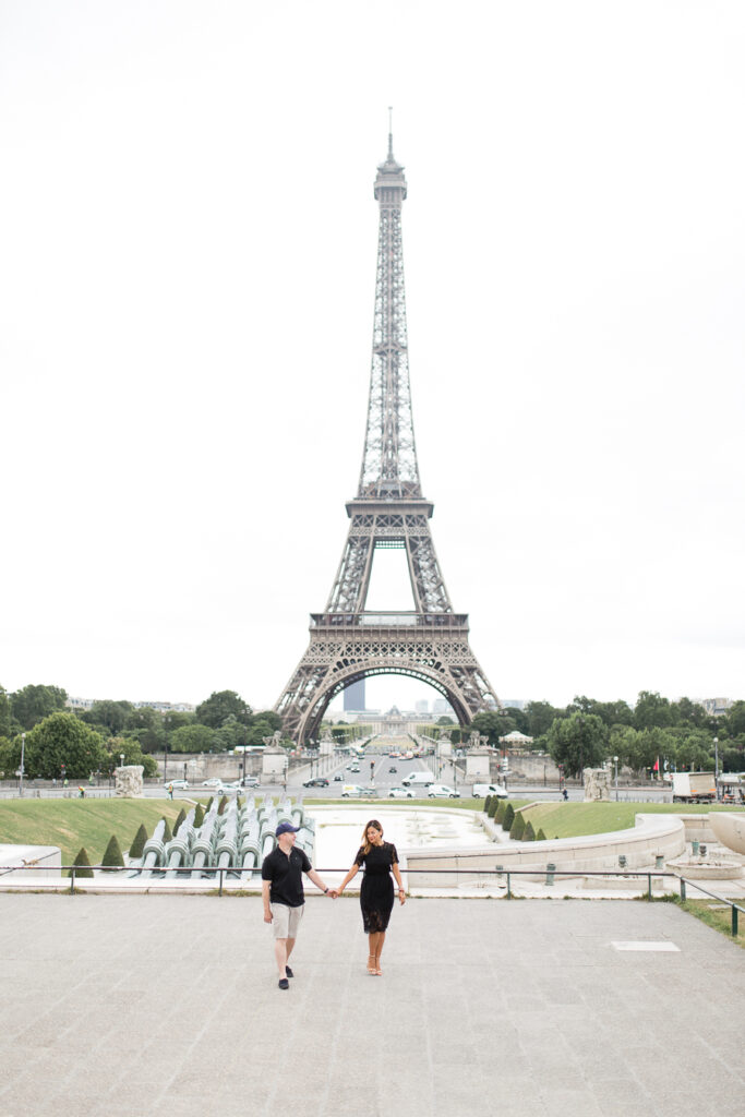 Couple crouching with their dog on Place Dauphine in Paris