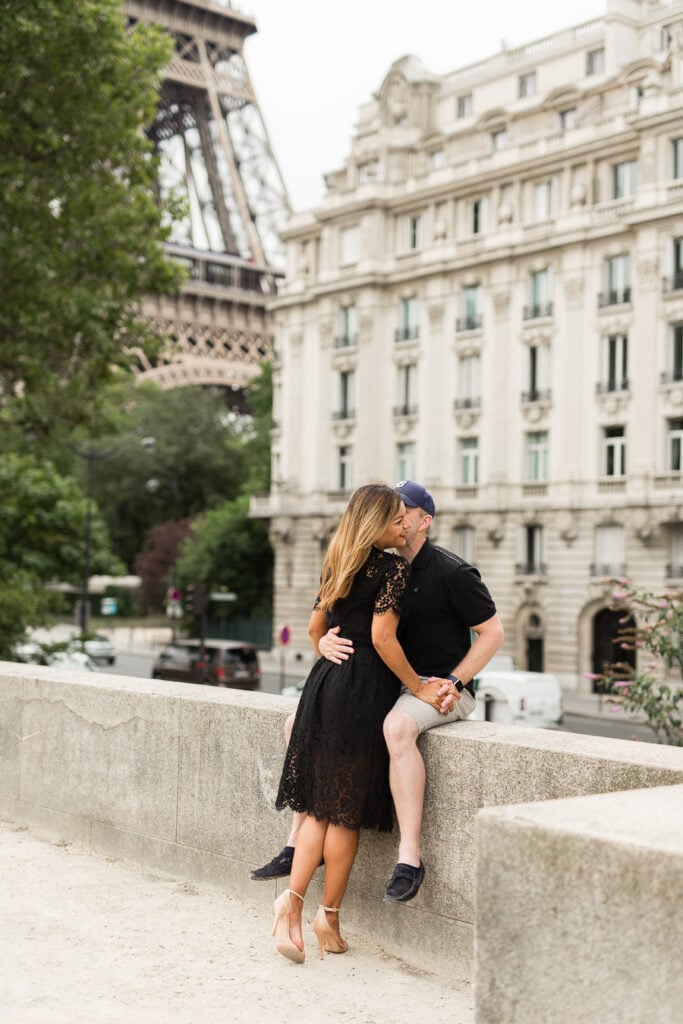 Couple walking hand in hand on the Pont Neuf with the Seine behind them