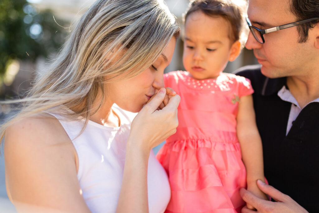 Close-up of parents nuzzling their toddler daughter during a family photoshoot in Paris