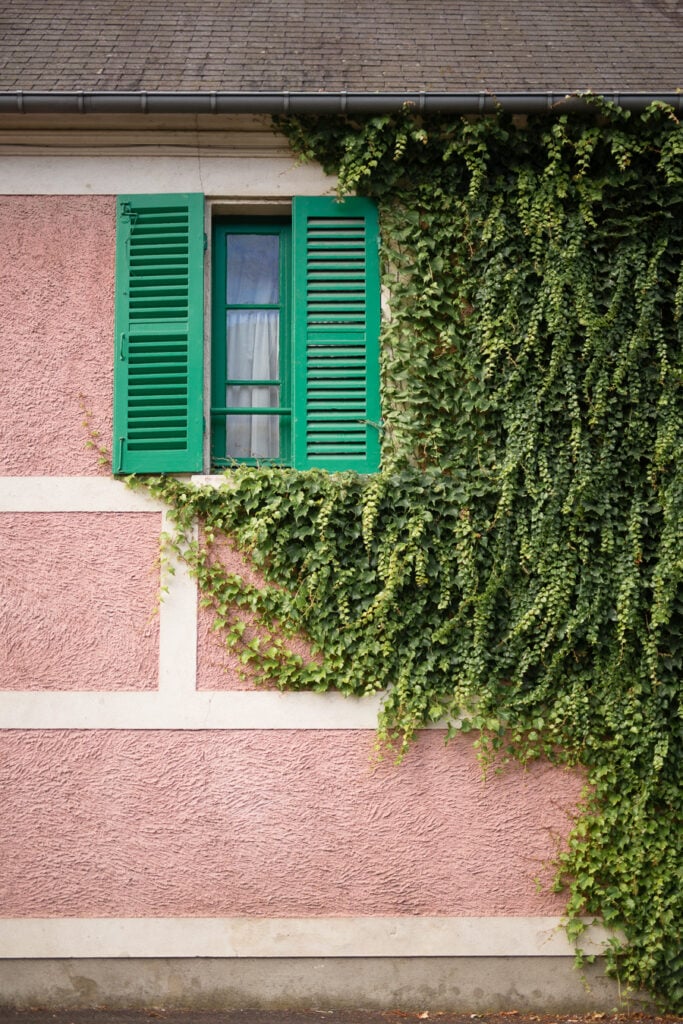 Pink facade with green shutters and ivy at Claude Monet's house in Giverny