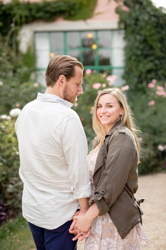Newly engaged couple holding hands in front of Monet's house in Giverny, France