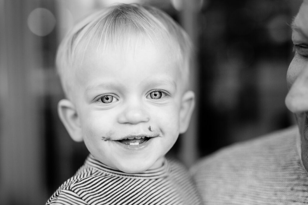 Black and white close-up of a grinning toddler during a family photoshoot in Paris