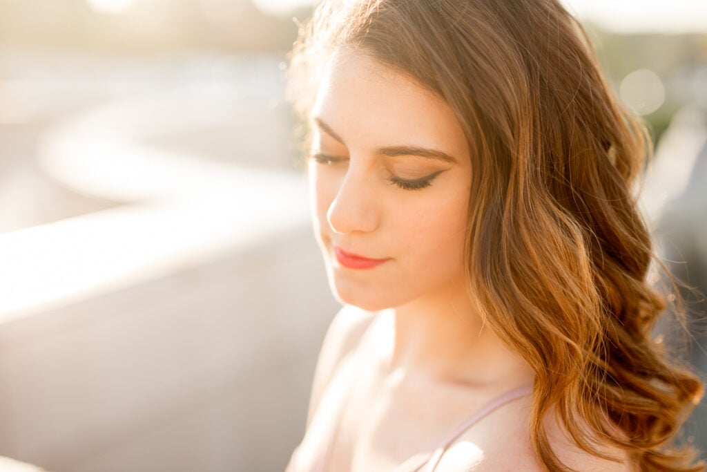 Close-up portrait of a teen ballerina with curled hair in soft morning light at Trocadéro