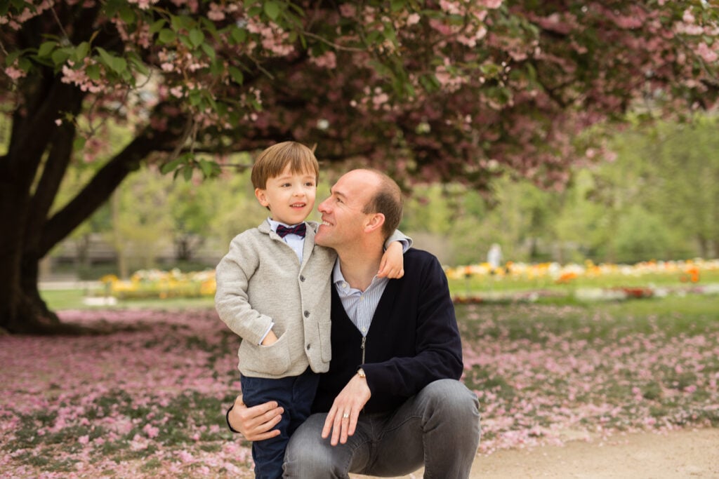 Portrait of dad and young son together during spring flower blossoms in Paris by Katie Donnelly Photography