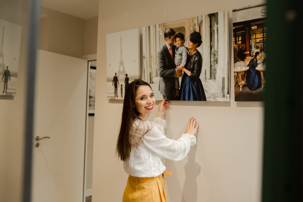 Paris family photographer, katie donnelly poses in her paris photo studio displaying the artwork