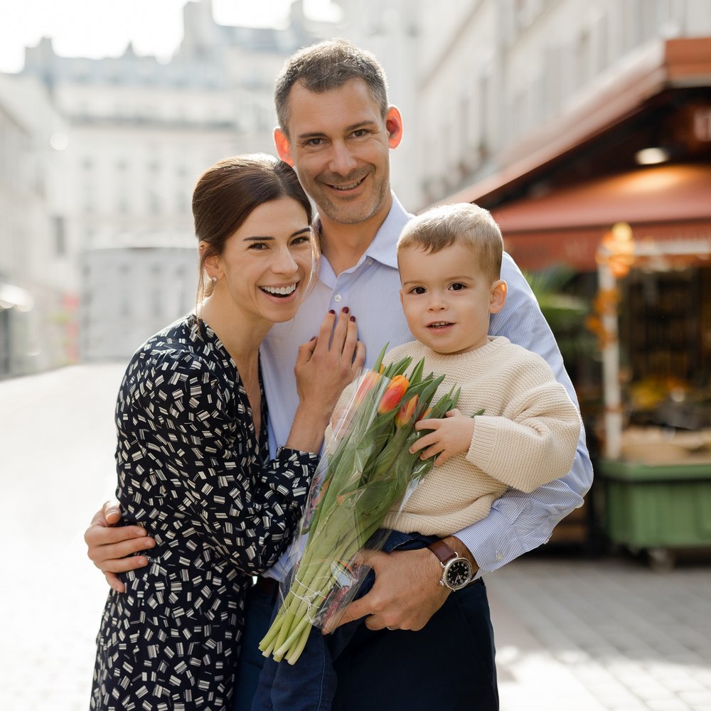 Family Portrait in Paris of Mom, Dad, and little boy holding a bouquet of tulips. Paris Photographer Katie Donnelly Photography