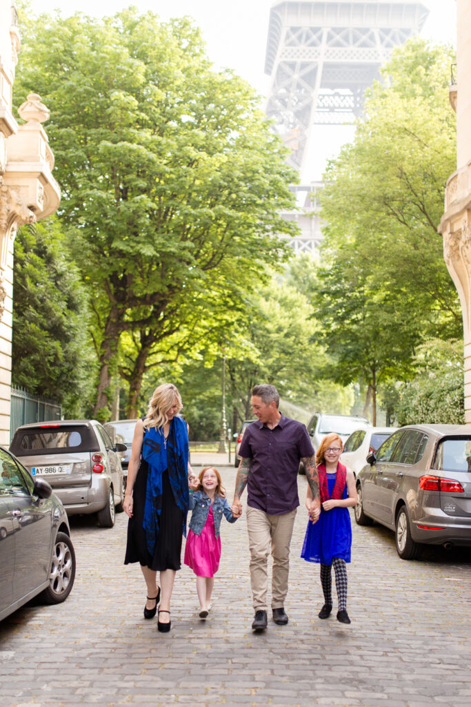 Family of four walking down a Paris street toward the Eiffel Tower