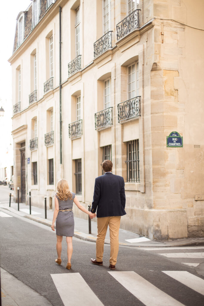 Couple crossing a quiet street on Île Saint-Louis in the evening light