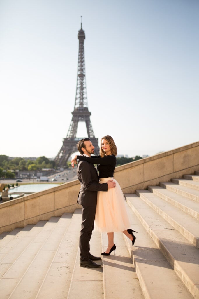 Couple embracing on the Trocadéro steps with the Eiffel Tower behind them