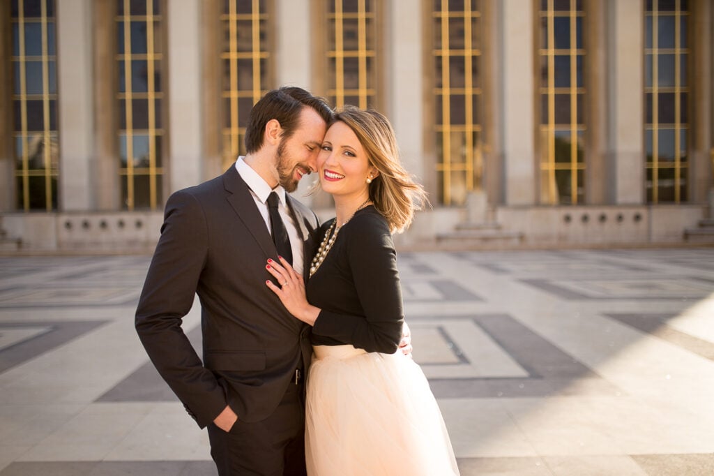 Couple embracing in front of the golden columns at Trocadéro in Paris