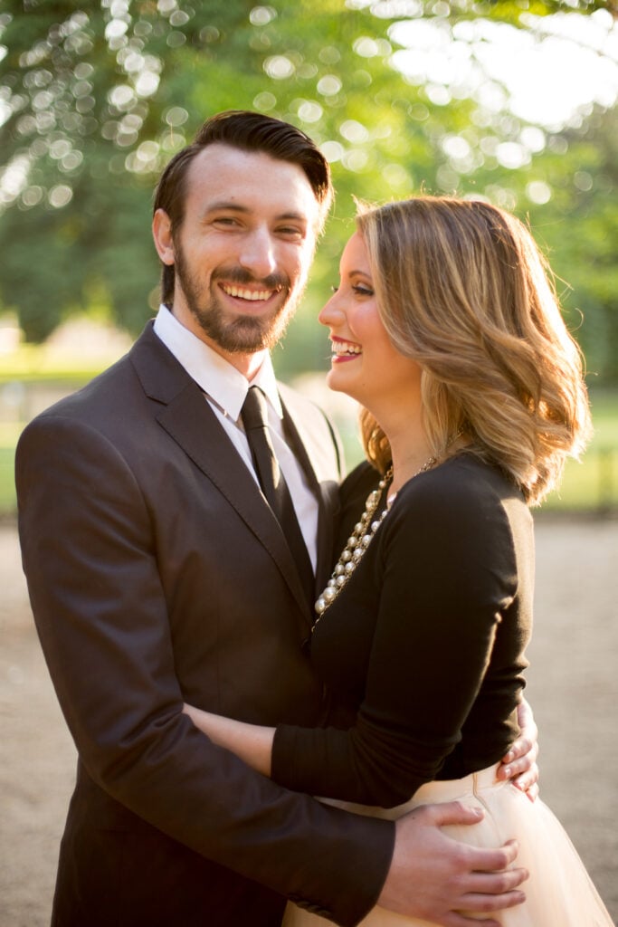 Couple laughing together in the Champ de Mars gardens during a Paris couples photoshoot