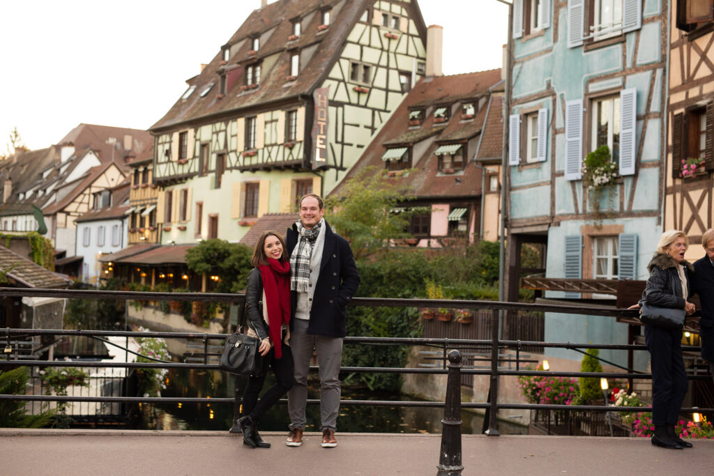 Couple standing on a bridge in front of the colorful houses of Little Venice in Colmar