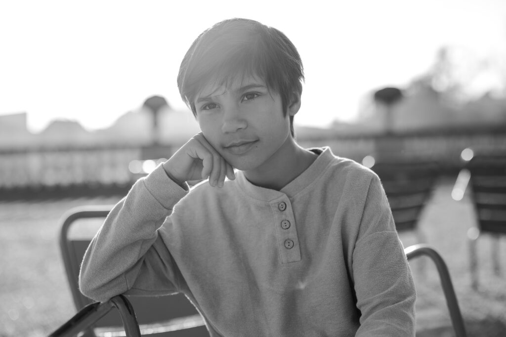 Black and white portrait of young boy at Luxembourg Gardens in Paris by Katie Donnelly Photography
