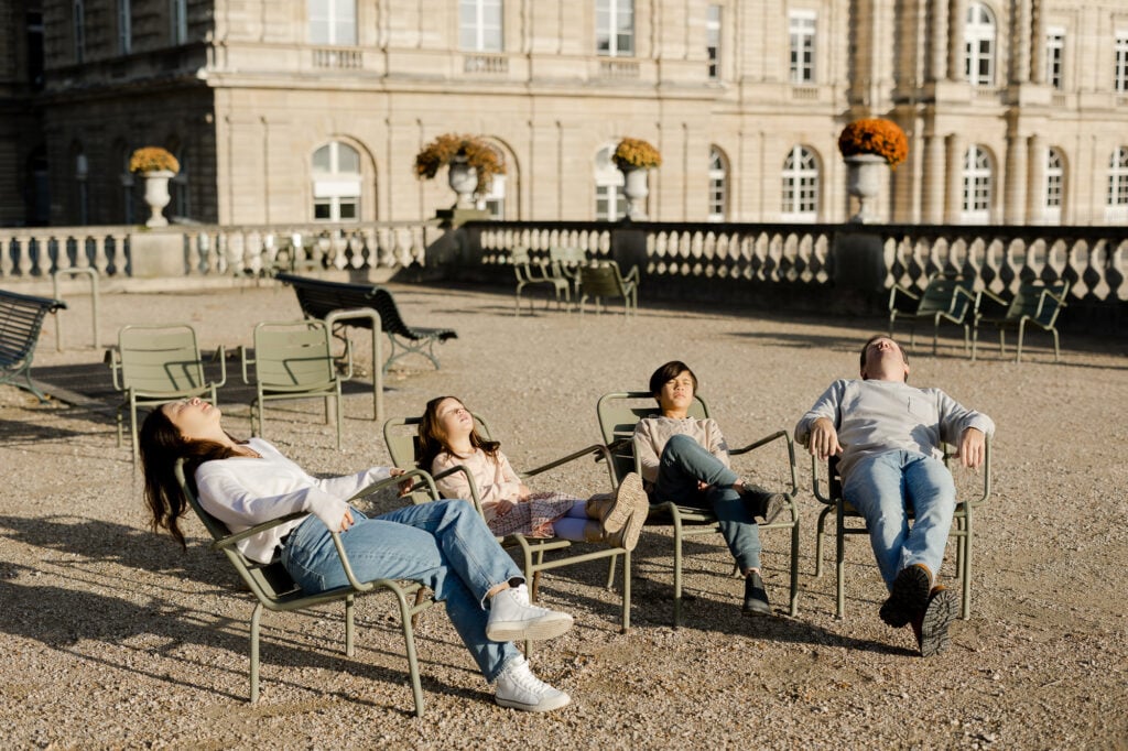 Creative family photoshoot ideas of family sitting in Luxembourg gardens Paris park by Katie Donnelly Photography