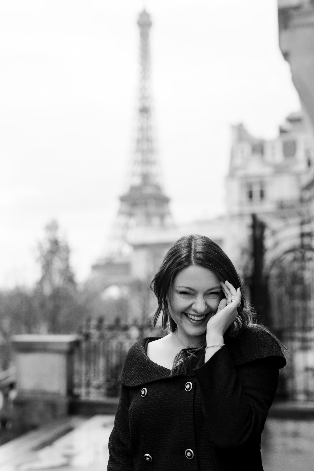 Black and white portrait of young woman in Paris with Eiffel Tower in background by Katie Donnelly Photography