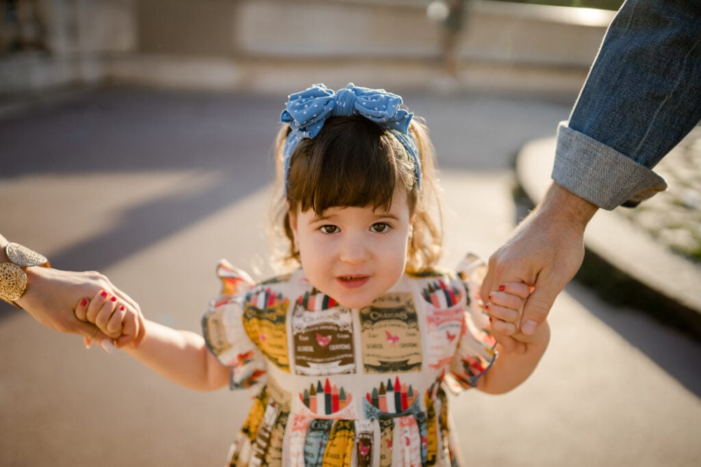 Portrait of young girl in colorful dress smiling in Paris by Katie Donnelly Photography