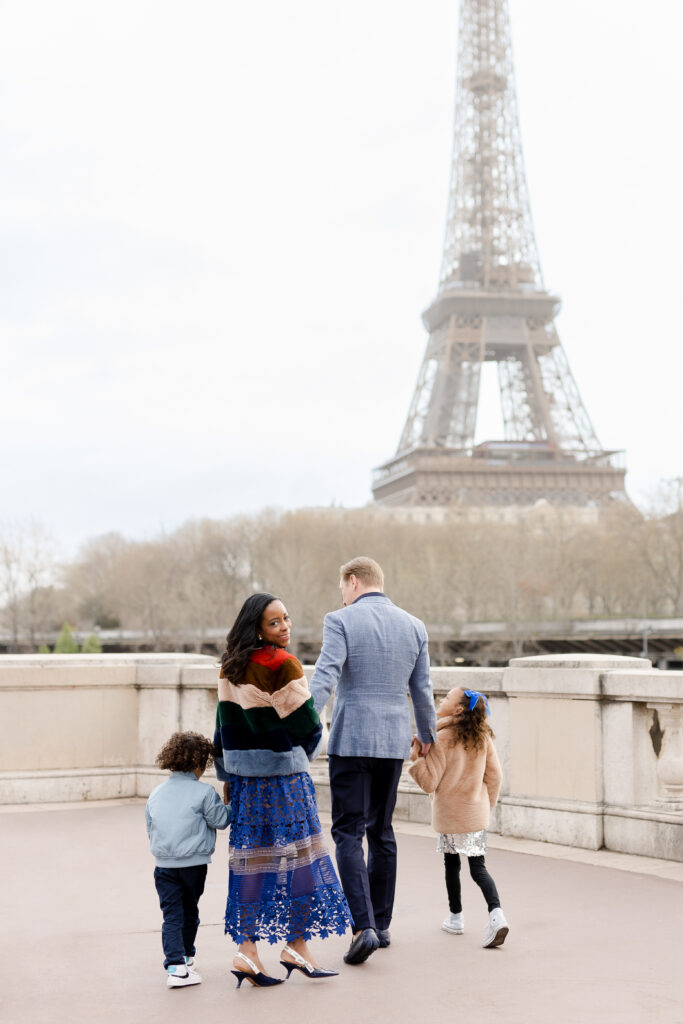 Parisian family photography: Family walking with Eiffel Tower views
