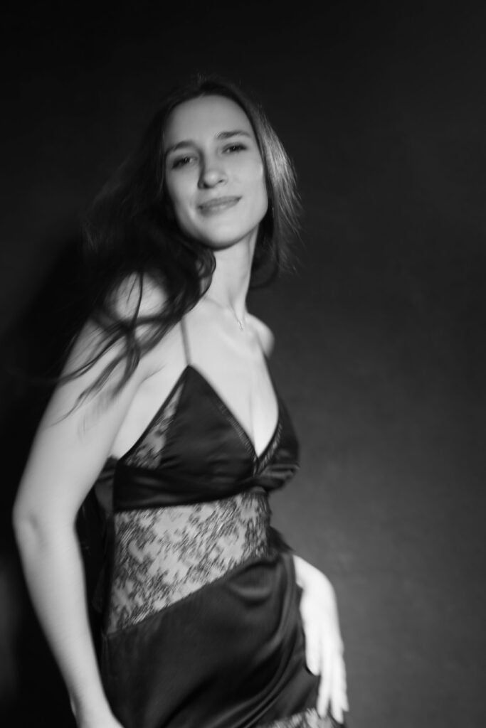 Black and white portrait of a woman in a satin and lace slip dress in a Paris boudoir studio