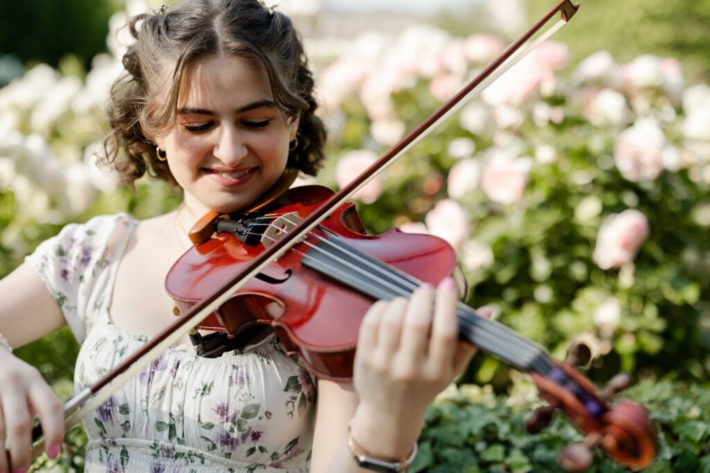 Young woman playing the violin in the Palais royal in Paris during a photo shoot by Paris Photographer, Katie Donnelly Photography