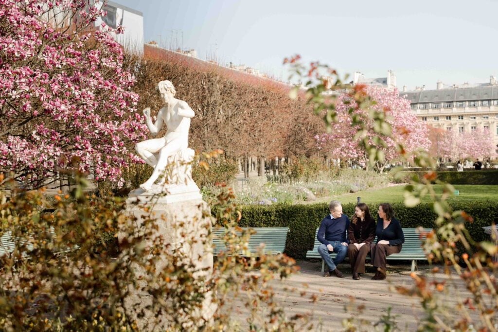 Family portrait at Paris park with statues and spring flower blossoms by Katie Donnelly Photography