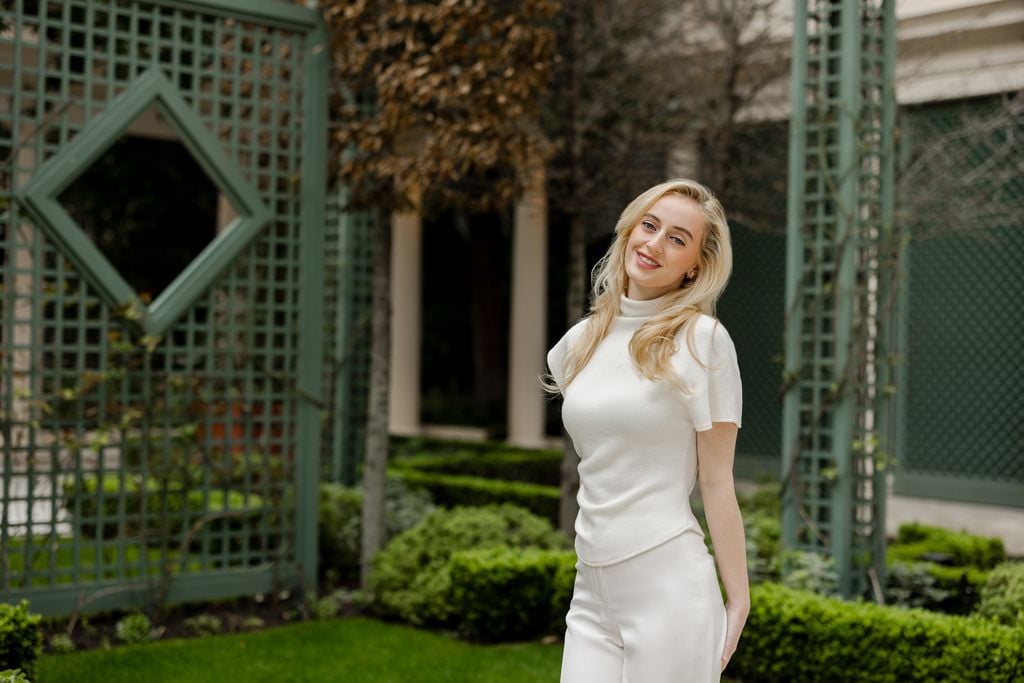 Portrait of young woman in all white posing at Le Bristol Hotel garden in Paris by Katie Donnelly Photography