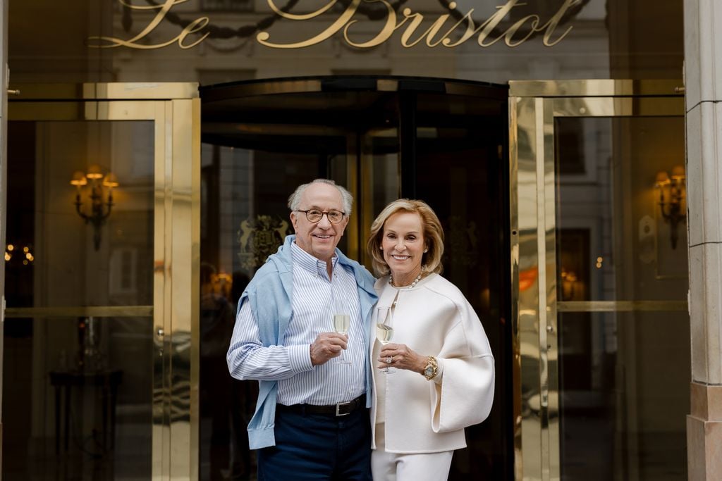 Portrait of older couple holding champagne glasses outside of Le Bristol Hotel in Paris by Katie Donnelly Photography