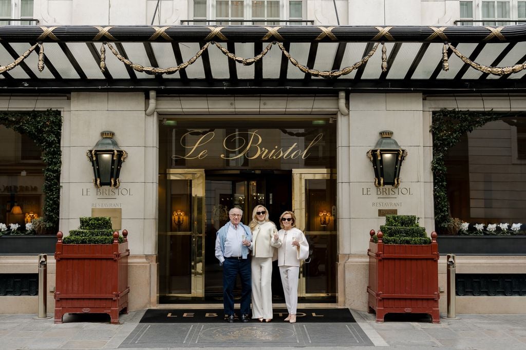 Portrait of three adults with champagne outside of Le Bristol Hotel in Paris by Katie Donnelly Photography