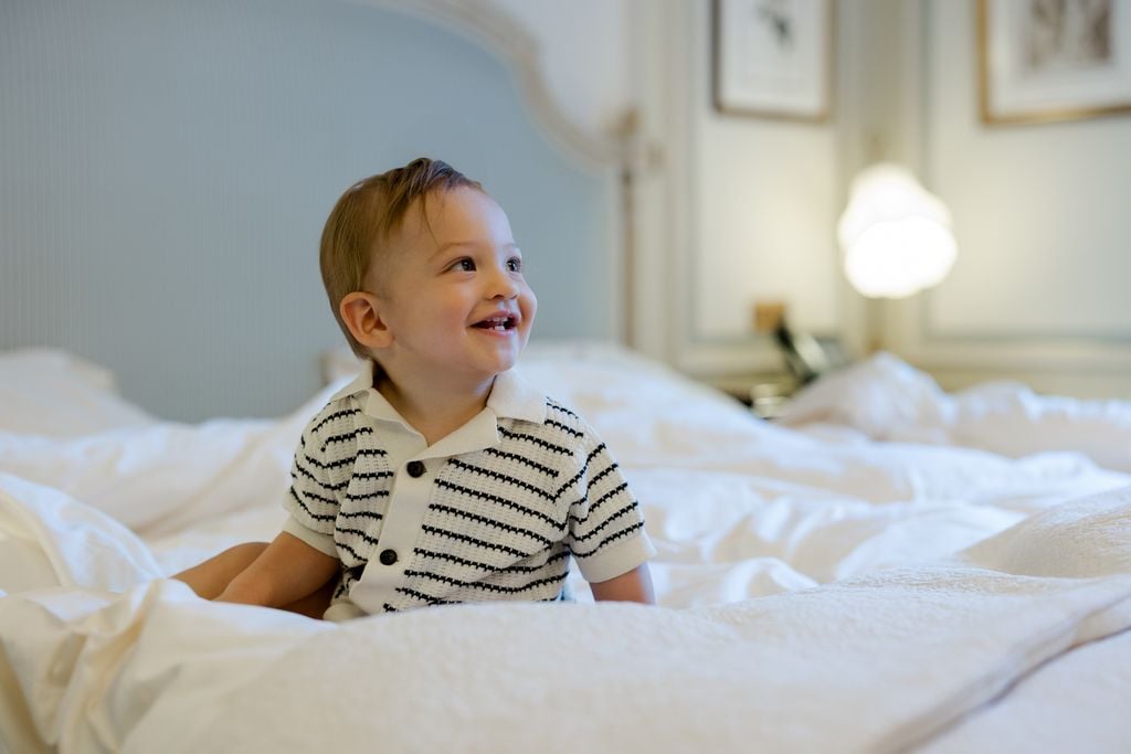 Portrait of young toddler on bed at the Ritz Hotel in Paris by Katie Donnelly Photography