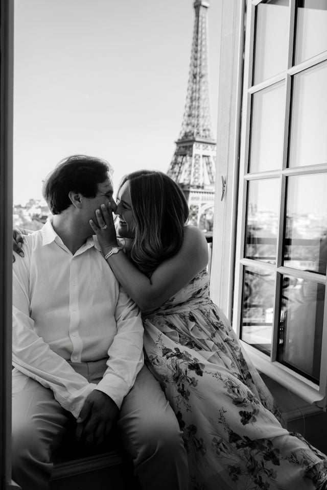 Black and white portrait of couple kissing in window of the Shangri-La Hotel with Eiffel Tower view by Katie Donnelly Photography