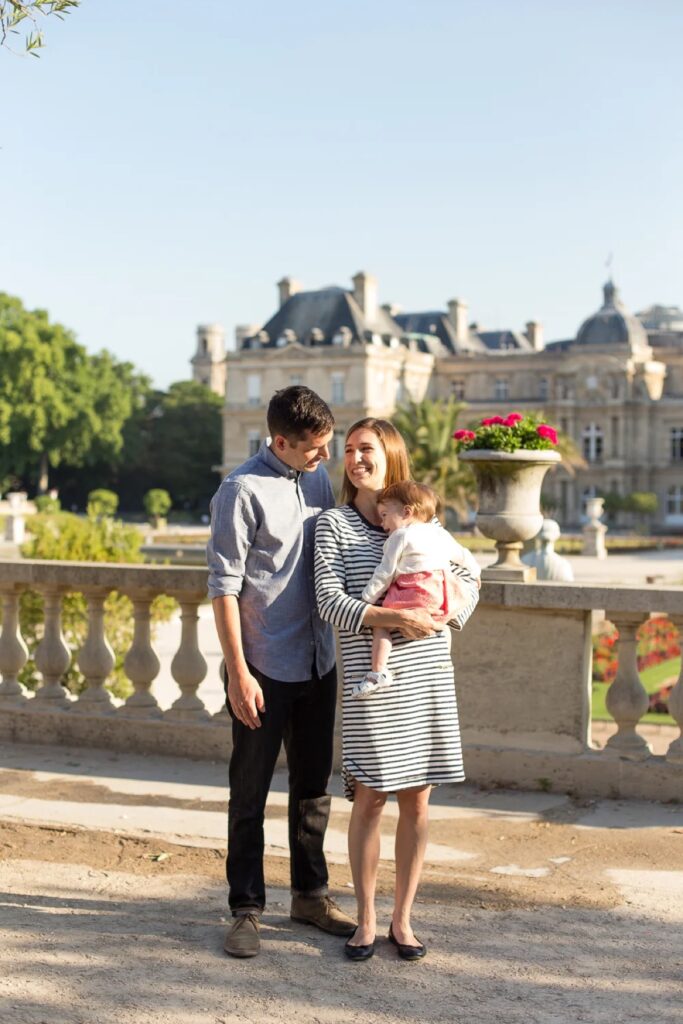 Family of three in coordinated blue, white and pink outfits at the Luxembourg Gardens in Paris