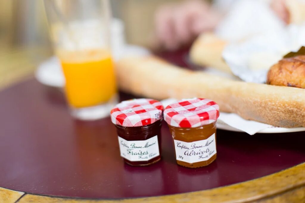 Small jars of jam and orange juice on a Paris café table