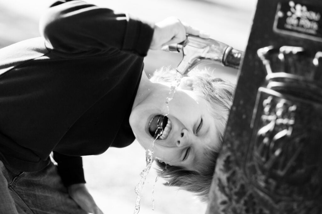 Black and white close-up of a laughing child hanging upside down