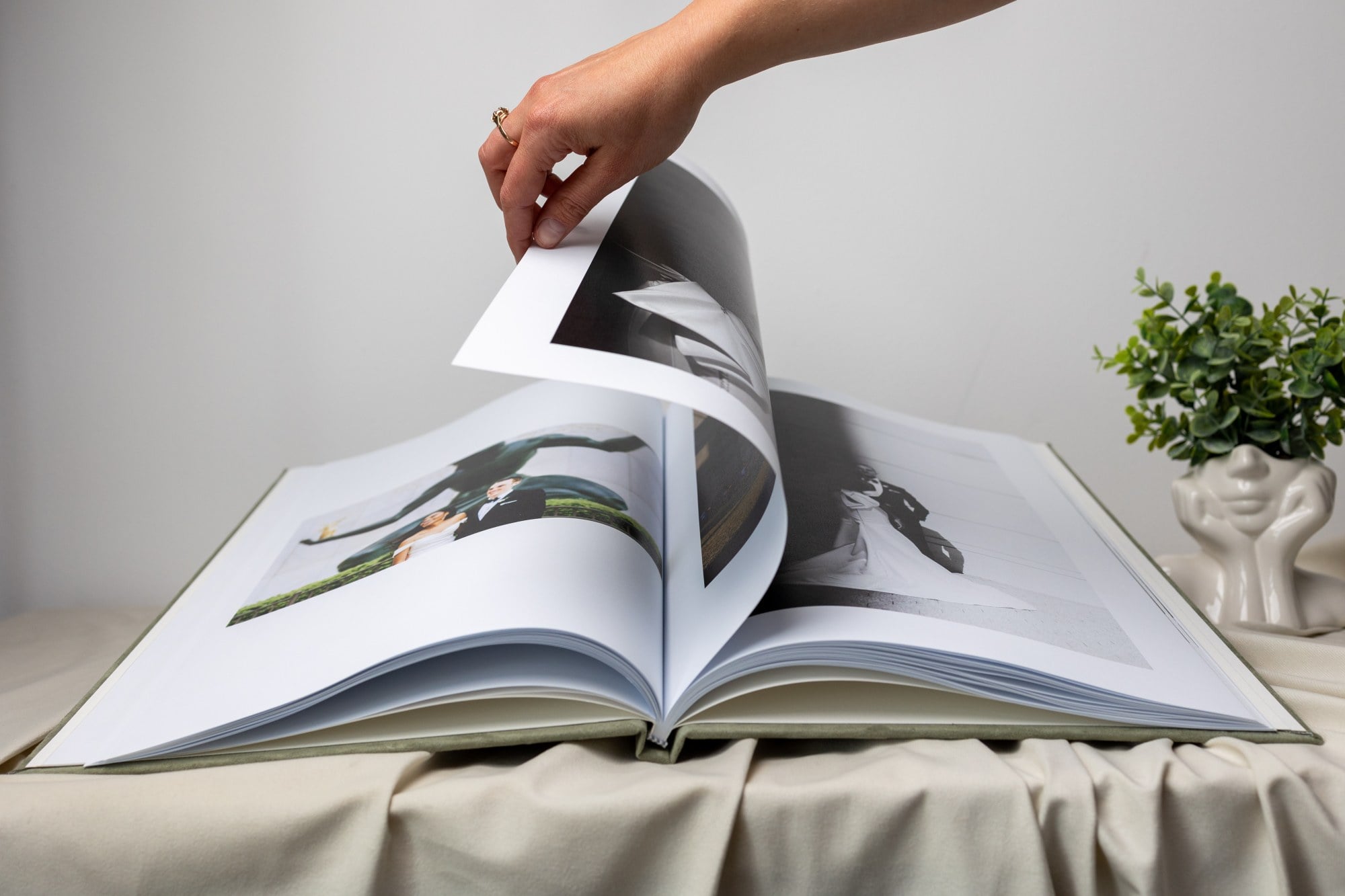 Hand turning a page of a large lay-flat heirloom photo album
