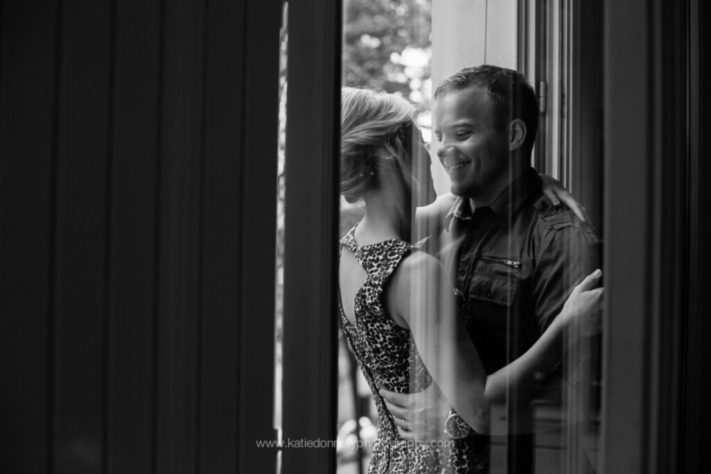 Black and white photo of a couple reflected in a window in Paris