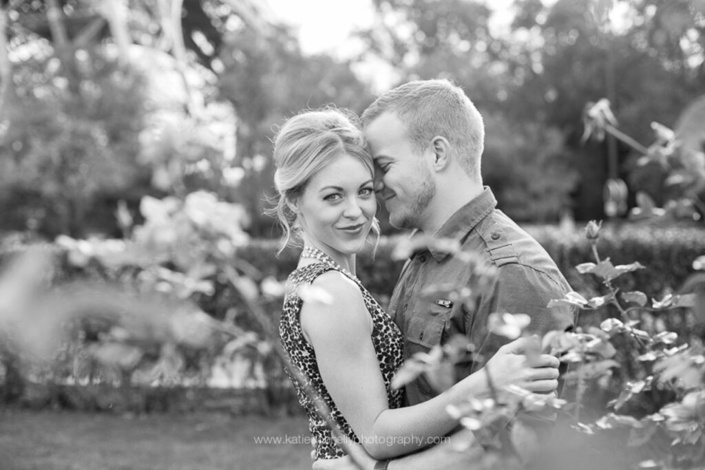 Black and white photo of a couple among the roses in a Paris garden