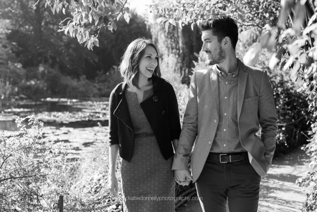 Black and white portrait of an engaged couple walking hand in hand in Giverny