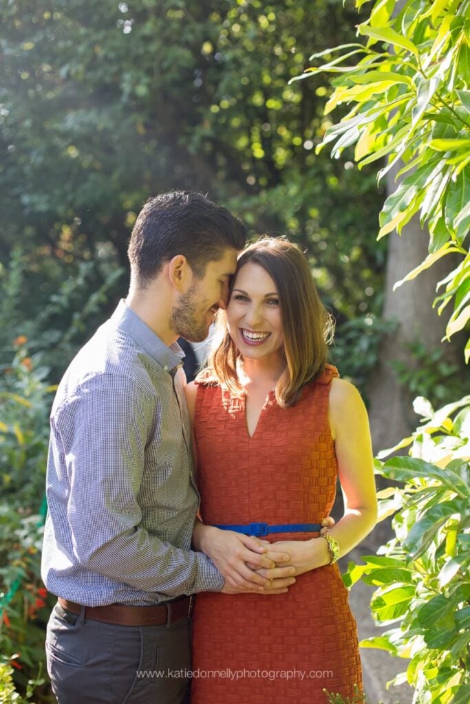 Engaged couple embracing in the greenery of Monet's garden in Giverny, France