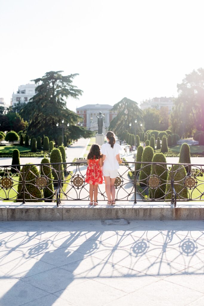 Mother and daughter looking out over El Retiro park in Madrid at sunset