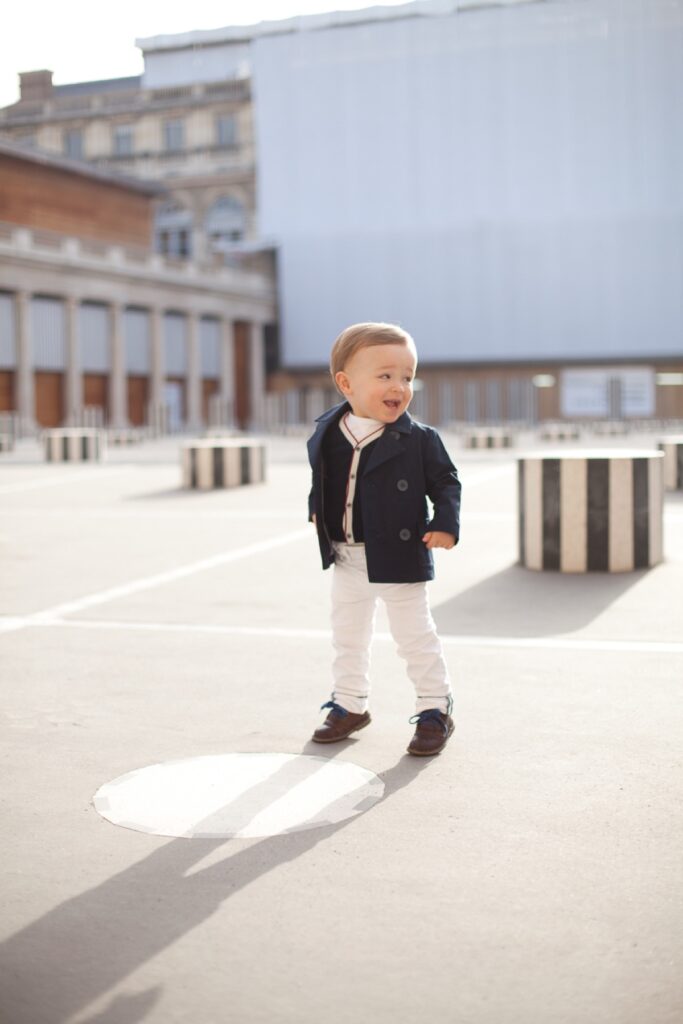 Toddler boy standing on his own in the courtyard of the Palais Royal