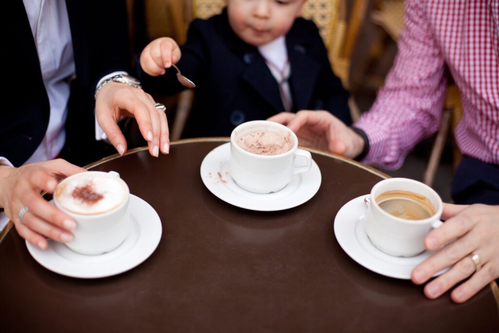Hands around cups of hot chocolate on a Paris café table