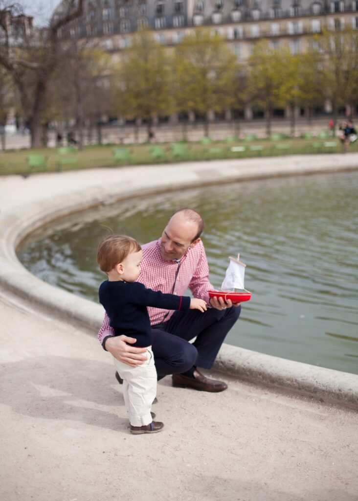 Dad and toddler son beside the fountain in the Palais Royal gardens
